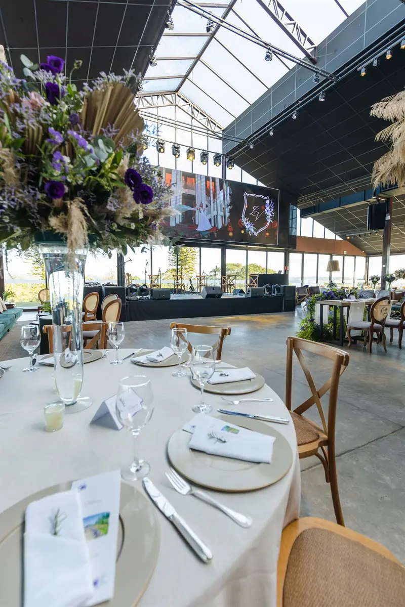 Mesa posta para o jantar do evento, com o palco ao fundo